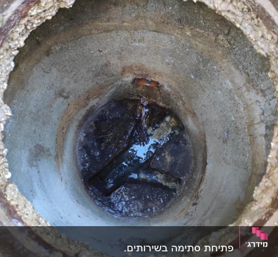 פתח ביוב עם מים עומדים בתחתית
